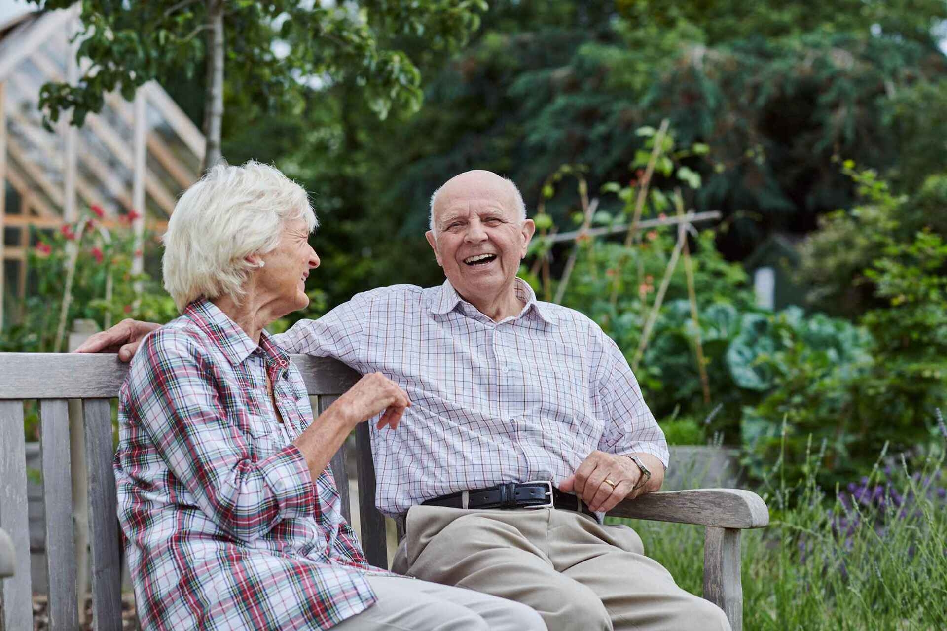 Couple on bench, smiling.